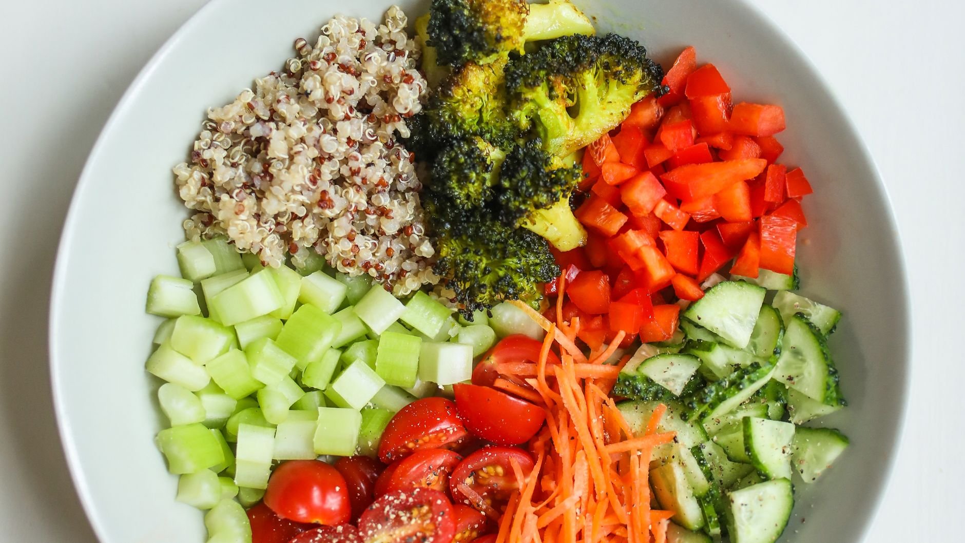 A white bowl of quinoa, broccoli, red pepper, celery, tomato, carrot and cucumber (illustrative stock photo)